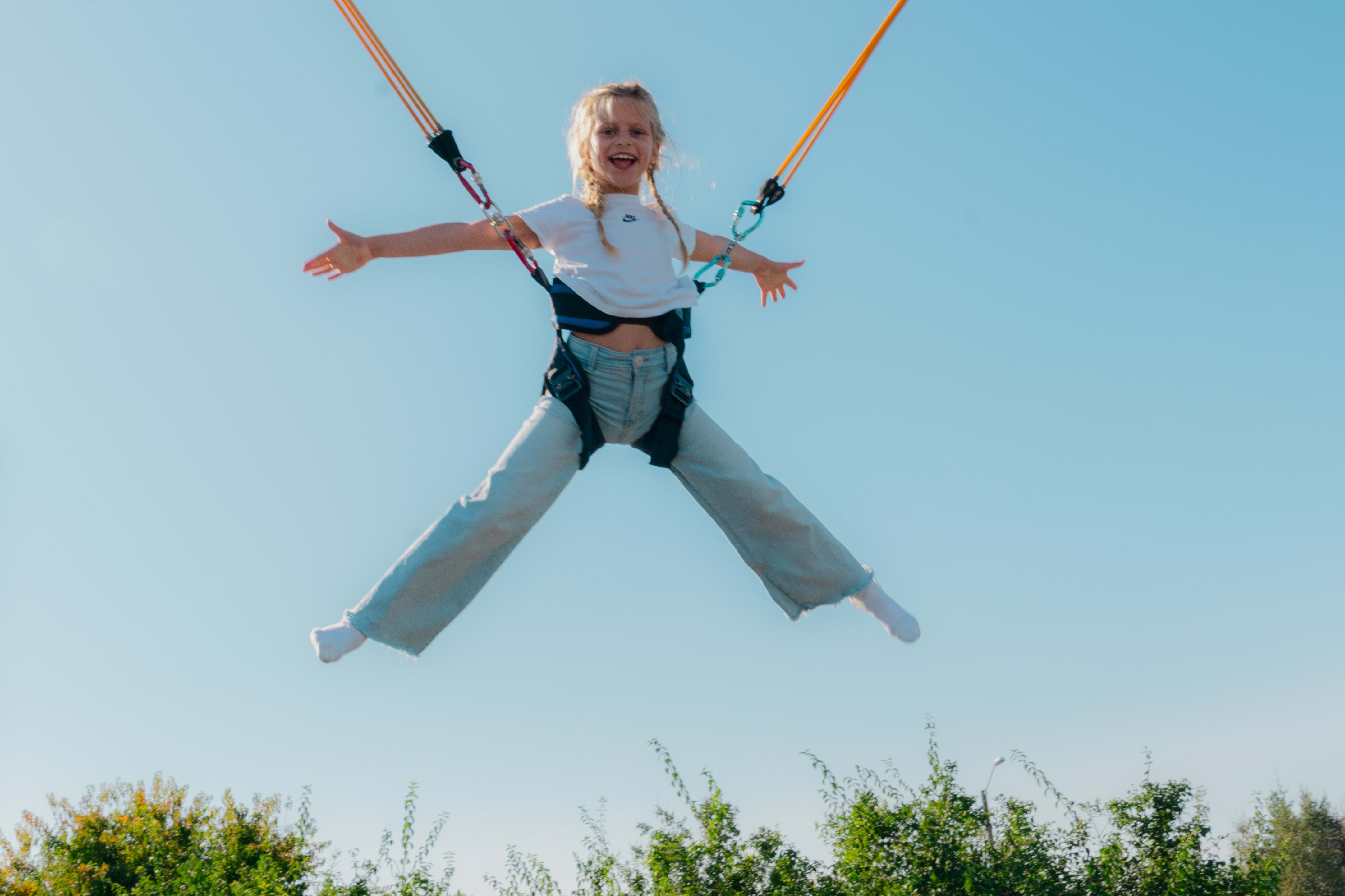 Jente som hopper på Bungee-trampoline